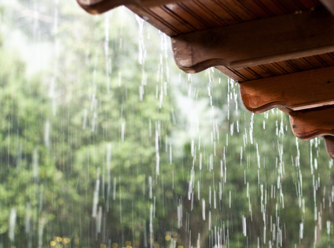 Regenwater dat van een dakgoot valt, benadrukt het belang van afkoppelen om schoon water gescheiden te houden van vuil rioolwater.